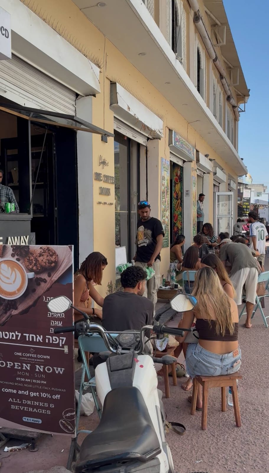 Guests seated outside the café on the sidewalk on a sunny afternoon